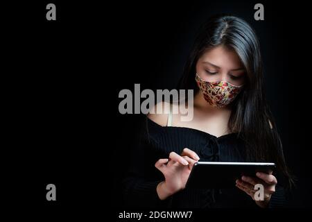 Schöne Frau mit Tablette in Pandemie Stockfoto