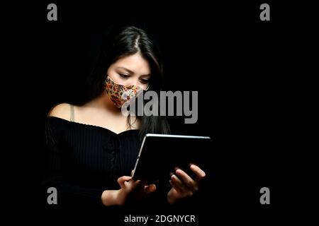 Schöne Frau mit Tablette in Pandemie Stockfoto