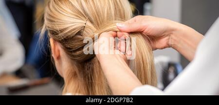 Nahaufnahme der Hände des Friseurs, die die Haare des Kunden umflechten In einem Schönheitssalon Stockfoto