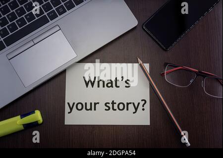 Was ist deine Story Card? Draufsicht auf Bürotisch Desktop-Hintergrund mit Laptop, Telefon, Brille und Bleistift mit Karte mit Aufschrift, was ist Ihr Stor Stockfoto
