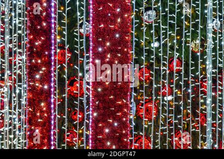 Viele Spiegelkugeln schmücken Weihnachtsbaum und Beleuchtung System Stockfoto