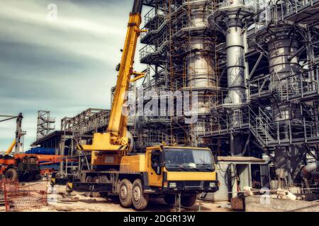 Auf der Baustelle steht ein großer gelber Autokran Stockfoto