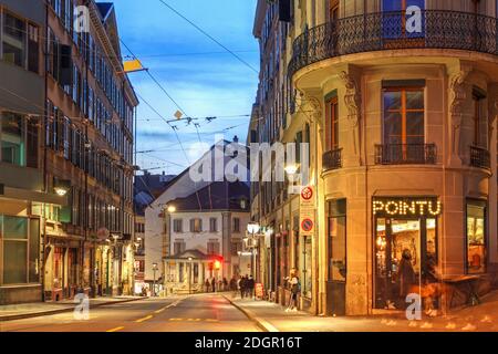 Straßenszene bei Nacht entlang der Rue Neuve in Lausanne, Schweiz, mit einigen alten Gebäuden unter den architektonischen Schätzen der Stadt. Stockfoto