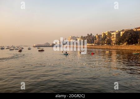 Schwarm von Hunderten von Tauben auf dem Wasser, mit touristischen Booten im Hintergrund, Mumbai Hafen, neben Gateway of India, Mumbai, Indien Stockfoto