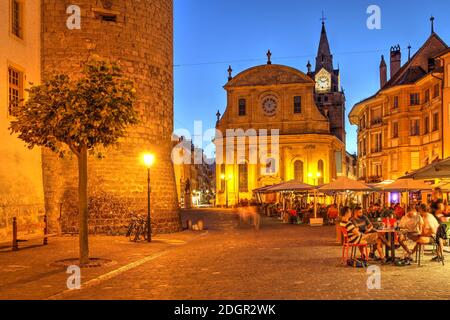 Nachtaufnahme auf dem Pestalozzi Platz in Yverdon les Bains, Schweiz mit der Stiftskirche und dem Chateau d'Yverdon. Stockfoto