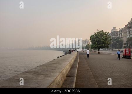 Einheimische trainieren an einem rauchigen Tag entlang der Promenade am Marine Drive im Süden von Mumbai, Indien Stockfoto