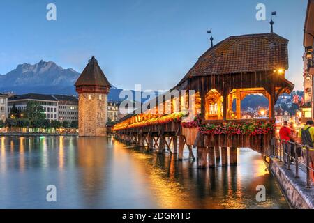 Abendszene mit der malerischen Kapellenbrücke über den Reuss, die aus dem Vierwaldstättersee entwässert, einem der ruhigsten Symbole der Schweiz. Stockfoto