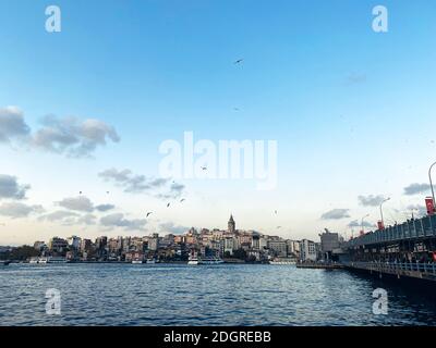 Die Galata-Brücke und der Galata-Turm auf dem Bosporus in Istanbul, Türkei. Blick auf Istanbul mit vielen Möwen und bewölktem Himmel. K Stockfoto