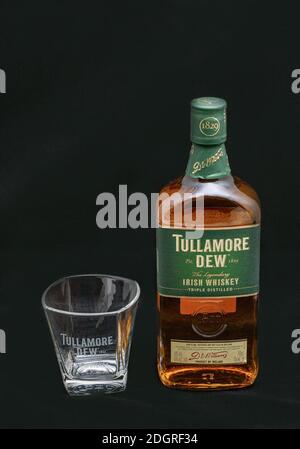 KIEW, UKRAINE - 17. AUGUST 2019: Flasche Tullamore TAU Irischer Blended Whiskey und Glas Nahaufnahme vor schwarzem Hintergrund. Es wird von William G produziert Stockfoto