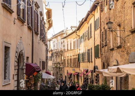 Montepulciano, Siena, Toskana, Italien, Dezember 2019: Hauptstraße in Montepulciano während der Weihnachtszeit schlendern Touristen, um Weihnachtsgeschenke zu kaufen. Stockfoto