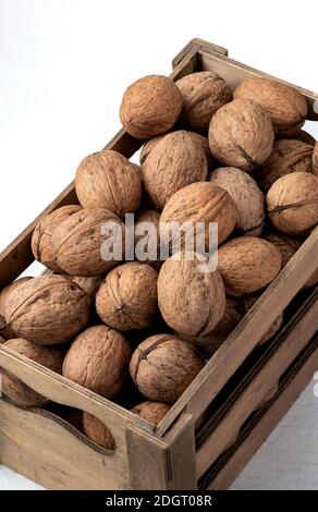 Viele Walnüsse in einer Mini-Holzkiste auf einem weißen Hintergrund auf Draufsicht Stillleben Fotografie Stockfoto