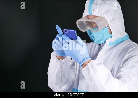 Porträt eines männlichen Arztes, der PSA mit Smartphone trägt Stockfoto