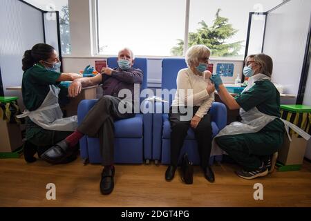 Ehemann und Ehefrau Vic und Penny Griffiths erhalten den Impfstoff Pfizer/BioNTech covid-19 am Basildon University Hospital in Basildon, Essex, da das größte Impfprogramm in der Geschichte Großbritanniens fortgeführt wird. Stockfoto