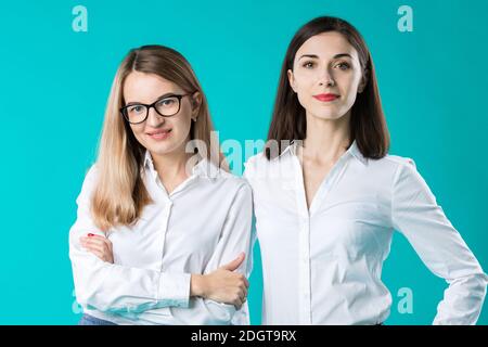 Porträt von zwei Frauen in Bürokleidung. Nette attraktive Geschäftsfrauen. Team von zwei lächelnden Geschäftsfrauen posiert. Zwei junge wome Stockfoto
