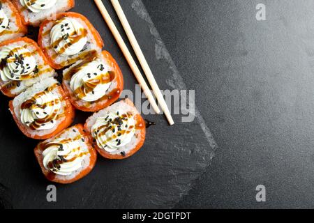 Sushi-Brötchen Philadelphia mit Lachs und gekrönt mit Frischkäse Stockfoto