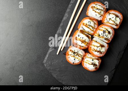 Sushi-Brötchen Philadelphia mit Lachs und gekrönt mit Frischkäse Stockfoto