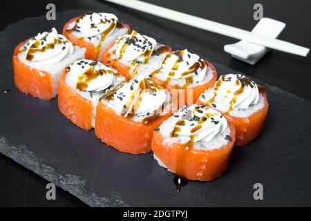 Sushi-Brötchen Philadelphia mit Lachs und gekrönt mit Frischkäse Stockfoto