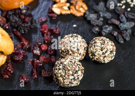Thema süße Dessert aus natürlichen Produkten ohne Zucker. Makro-Nahaufnahme von Desserts Kugel rund Bonbon Trüffel auf einem schwarzen Plat Stockfoto
