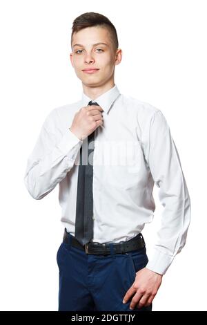 Zuversichtlich ernst Teenager Kerl mit Händen in seiner blauen Jeans Taschen tragen weißes Hemd und schwächen Krawatte. Isoliert auf weißem Backgro