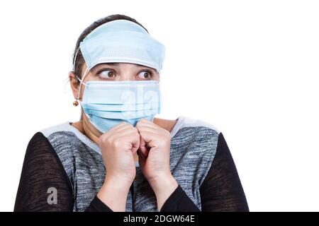 Lustige Angst Gesicht des jungen Mädchens in medizinische Maske isoliert auf einem weißen. Stockfoto