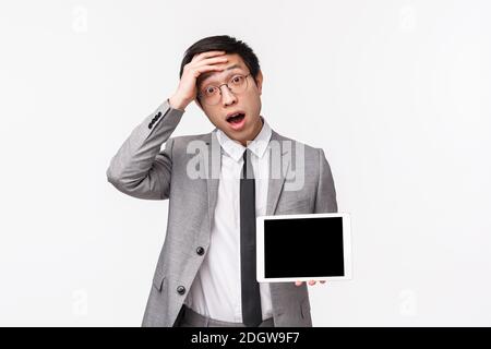 Taille-up-Porträt von schockiert und erstaunt jungen asiatischen Mann in Anzug realisiert etwas wichtiges, erinnern, berühren Stirn aussehen Stockfoto