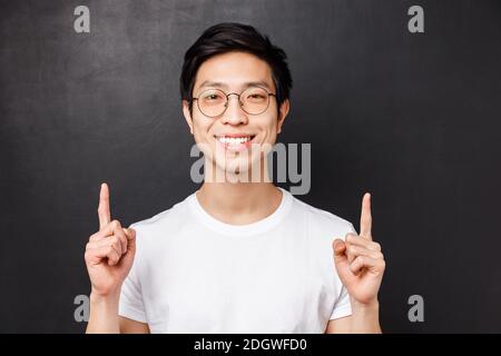 Nahaufnahme Porträt von erfolgreichen zufrieden jungen asiatischen männlichen Unternehmer, zeigt die Finger nach oben und suchen Kamera mit zufriedenen Ba Stockfoto