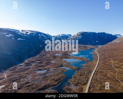 Bergpassstraße, die im Herbst durch zerklüftetes Gelände und Seen im Hochland führt. Antennenvideo. Stockfoto