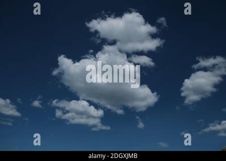 Definierte weiße Wolken auf einem tiefblauen Himmel Stockfoto