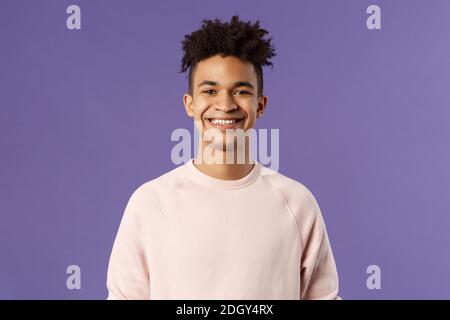 Nahaufnahme Porträt von fröhlichen jungen Hipster Kerl mit Angst, lächelnd optimistisch und erfreut, stehen lila Hintergrund, havin Stockfoto