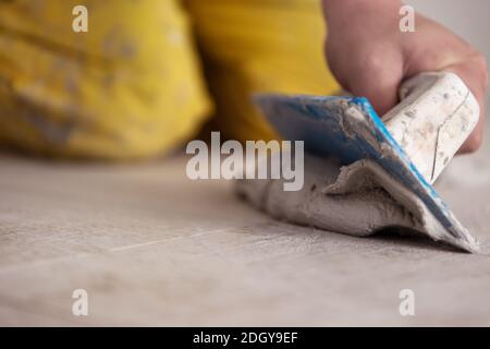 Fliesenleger füllen den Raum zwischen keramischen Holz-Effekt Fliesen Stockfoto