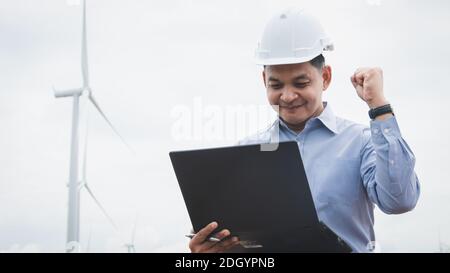 Ingenieure Windmühlen arbeiten an Laptop mit der Windenergieanlage in Hintergrund Stockfoto