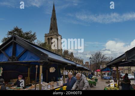 Bedford Market, Bedfordshire, Großbritannien. Ältere Menschen, die am Obst- und Gemüsestandplatz auf dem Markt unter dem Kirchturm des hl. Paulus einkaufen Stockfoto