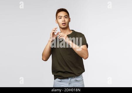 Portrait von erschrocken jungen asiatischen Kerl, männlichen Studenten keuchen und springen erschrocken, wie jemand unerwartet erschien, heben die Hände d Stockfoto