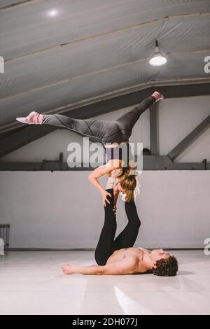 Yogi Paar Praxis. Paar junge sportliche MenschenÜben akrobatischen Yoga-Unterricht mit Partner, Mann und Frau in yogi Übung, ein Stockfoto