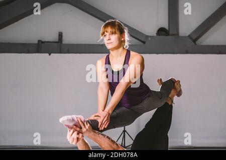 Themensport und ein gesunder Lebensstil. Akrobatik und acroyoga. Junge sportliche Paar üben acroyoga Handstand. Männlich und weiblich Stockfoto