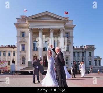 Sewastopol, Russland - 29. September 2020: Ältere Paare tanzen den Walzer über dem Hintergrund des Gebäudes des Lunatscharski Dramatheaters. Frauen in Beautifu Stockfoto