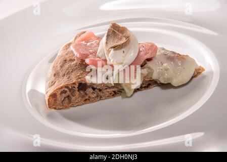 Gourmet-Pizza mit weißem Trüffel, Vollkornfocaccia mit geschmolzenem Käse, rohem Fleisch, Mozzarella und Scheiben weißer Trüffel, Nahaufnahme Stockfoto