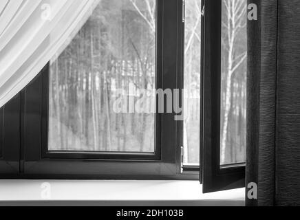 Fragment eines teilweise geöffneten Fensters mit Vorhängen Stockfoto