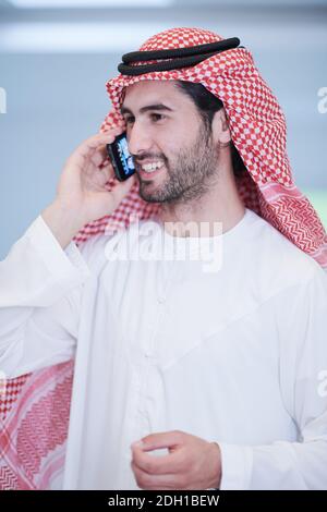 Junger arabischer Geschäftsmann mit Smartphone zu Hause Stockfoto