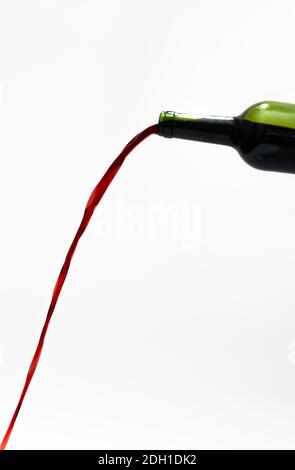 Isolierter Rotwein Gießen aus einer Flasche mit lang Stream auf weißem Hintergrund Stockfoto