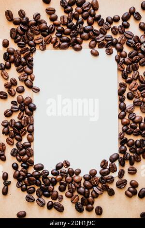 Kaffeebohnen und ein leeres weißes Papier Stockfoto