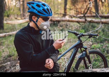 Radsportler mit Gesichtsmaske, mit Filter PM 2.5. Thema Coronavirus oder Covid 19. Sportler in Schutzmaske mit Fahrrad Stockfoto