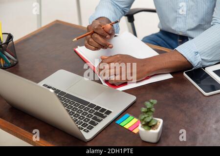 Lektion. Online englischkurse zu Hause. Nahaufnahme der Hände des Menschen während der Vermittlung Schüler aus der Ferne im Inneren des Wohnzimmers. Verwenden von Geräten. Konzept der Bildung, Quarantäne, moderne Gadgets. Stockfoto