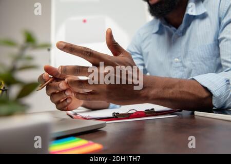 Lehrer. Online englischkurse zu Hause. Nahaufnahme der Hände des Menschen während der Vermittlung Schüler aus der Ferne im Inneren des Wohnzimmers. Verwenden von Geräten. Konzept der Bildung, Quarantäne, moderne Gadgets. Stockfoto
