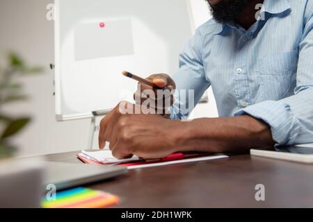 Lehrer. Online englischkurse zu Hause. Nahaufnahme der Hände des Menschen während der Vermittlung Schüler aus der Ferne im Inneren des Wohnzimmers. Verwenden von Geräten. Konzept der Bildung, Quarantäne, moderne Gadgets. Stockfoto