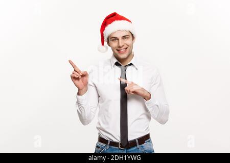 Christmas Concept - Handsome Business man tragen santa Hut Zeigen Finger auf der Seite mit weißen isolierten Hintergrund. Stockfoto