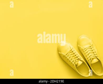 Gelbe Sneakers auf gelbem Hintergrund, Kopierraum Stockfoto