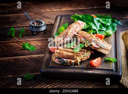 Gegrillte Sandwich Panini mit Schinken, Tomaten, Käse und Spinat. Leckeres Frühstück oder Snack. Speicherplatz kopieren Stockfoto