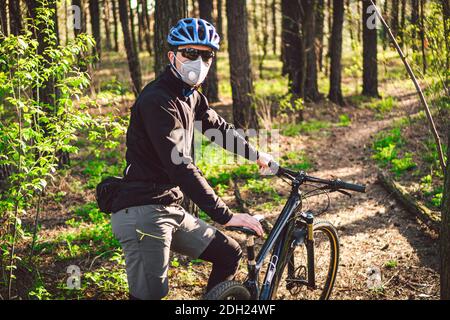 Sport. Mountain Bike Radfahrer Reiten Single Track. Mann auf dem Fahrrad trägt Atemschutzmaske Gesichtsmaske mit schweren Schutzfilter. Sa Stockfoto