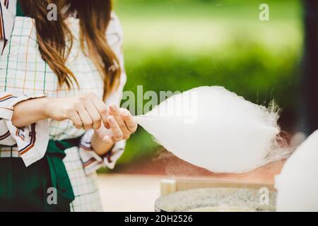 Thema ist eine Familie kleines Unternehmen Kochen Süßigkeiten. Hände close-up Junge Frau Händler Besitzer des Outlet macht eine Zuckerwatte, fair Stockfoto